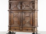 une photo montrant une grande armoire en bois montée sur roulettes dans une pièce