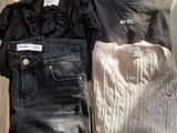 two pairs of jeans and a sweater are sitting on a wooden shelf