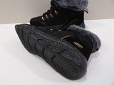 pair of black snow boots with fur lined on top of a white table