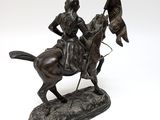 bronze statue of a man on a horse holding a flag