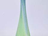 a blue and green vase sitting on a white surface