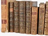 many old books lined up on a white surface