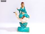 une figurine représentant une femme assise sur un cygne