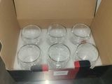 six empty glasses in a box on the counter