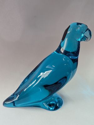 un oiseau en verre bleu posé sur une table