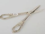 pair of silver scissors on a white surface with a price tag on it