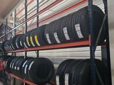 tires on a rack in a warehouse with shelves full of tires
