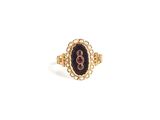 Gros plan sur une bague en or ornée d'une pierre noire
