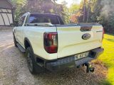 a white pickup truck parked in the driveway of a house
