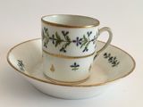 a tea cup and saucer on a white table