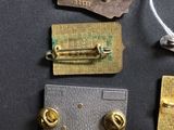 four different types of metal tags on a black surface
