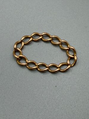 gros plan d'un bracelet en chaîne en or sur une surface grise