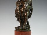 une image représentant une statue en bronze de deux personnes posée sur un socle en marbre