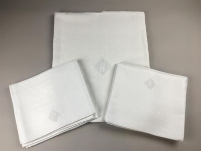 three white napkins with embroidered designs on them sitting on a table