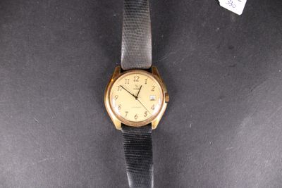 an image of a gold watch with a black strap on a black surface