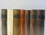 books are lined up in a row on a white surface