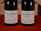 two bottles of wine sitting on a table next to each other