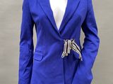 the woman is wearing a blue blazer and black pants