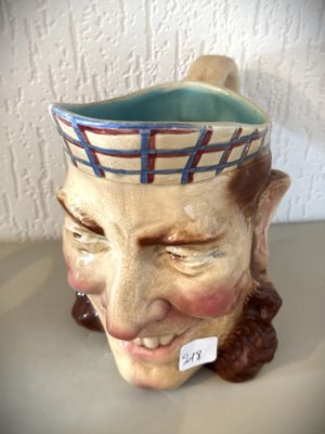 une tête d'homme en céramique coiffée d'un chapeau
