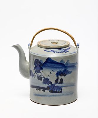 une théière bleue et blanche avec une poignée en bois