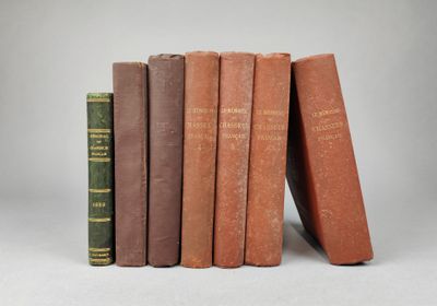plusieurs vieux livres sont empilés sur une surface blanche