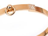 a close up of a gold bracelet with diamonds on a white background