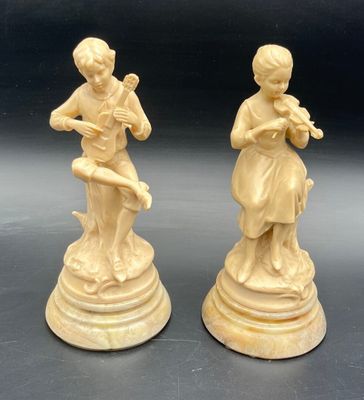 pair of carved ivory figurines of a boy and a girl