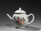 a white teapot with a floral design on it