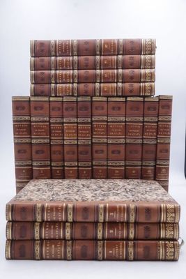 many books stacked on top of each other on a bench