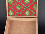 an old wooden box with a red and green pattern on it