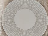 une assiette blanche décorée d'un motif, posée sur une table