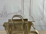 gold leather handbag on a wooden table with a white wall in the background