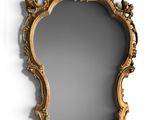 an ornate gold framed mirror on a wall next to a white wall
