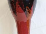 a black and red vase sitting on a white surface