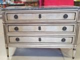 a small chest of drawers with marble top