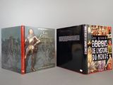 Trois livres sont posés sur une table devant un fond gris.
