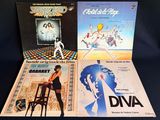 three vinyl records of various movies on a black background