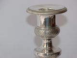 a silver candle holder on a table with a white background