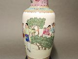 a vase with a painting on it sitting on a table