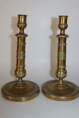 paire de chandeliers anciens en laiton sur fond blanc