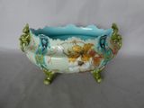 a blue bowl with flowers on it sitting on a table
