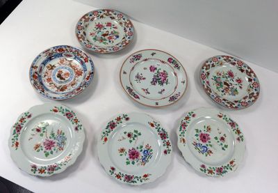 Plusieurs assiettes ornées de motifs floraux sont disposées sur une surface blanche