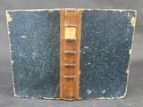 un vieux livre avec une couverture en bois sur laquelle est posé un marque-page