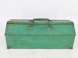 an old green tool box sitting on top of a white surface