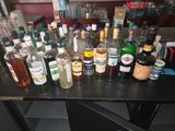 Des bouteilles d'alcool sont alignées sur une table dans un bar
