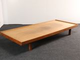 une photo d'une table basse en bois posée sur un sol recouvert de moquette