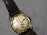 une photo d'une montre-bracelet avec un bracelet en cuir posée sur une table