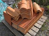une pile de briques d'argile posée sur une palette à côté d'un camion