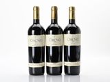 three bottles of red wine sitting next to each other on a white surface