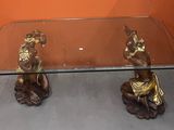une table en verre sur laquelle sont posées deux figurines